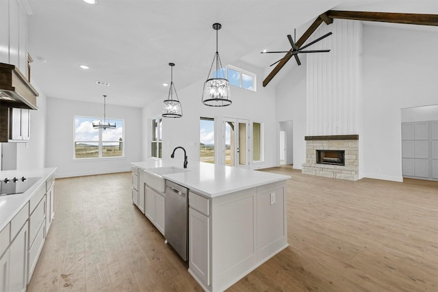 kitchen featuring white cabinetry, stainless steel dishwasher, sink, and a center island with sink