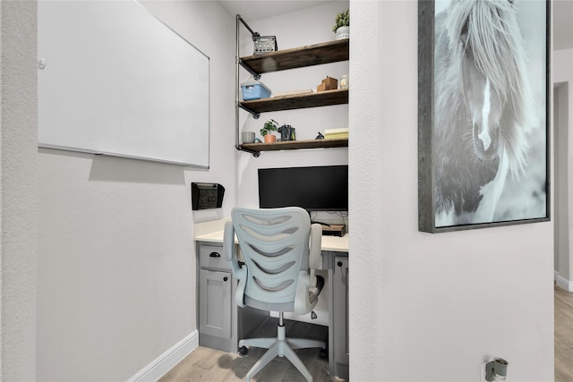 office area with built in desk and light hardwood / wood-style floors