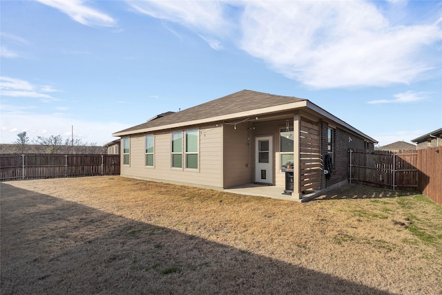 rear view of property with a patio and a lawn