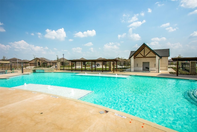 view of swimming pool with pool water feature and a patio