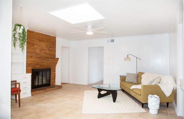 living room with visible vents, a brick fireplace, a skylight, and a ceiling fan