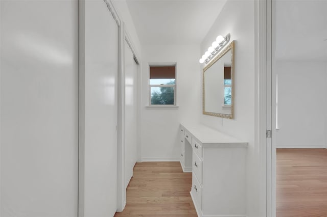 bathroom with baseboards, wood finished floors, and vanity