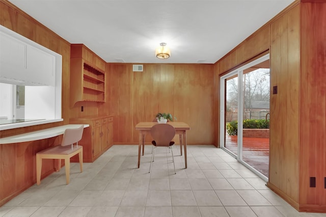 tiled office space featuring wooden walls