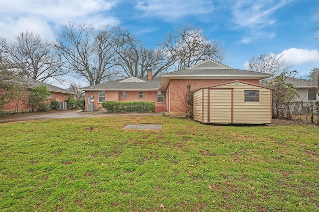 view of front of house featuring an outbuilding, a storage unit, a front lawn, and fence