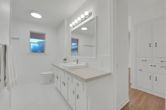 bathroom with vanity, hardwood / wood-style flooring, and toilet