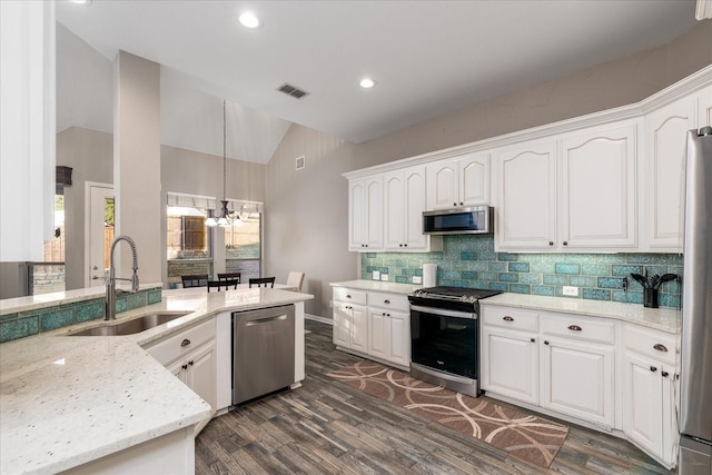 kitchen featuring stainless steel appliances, lofted ceiling, visible vents, white cabinets, and a sink