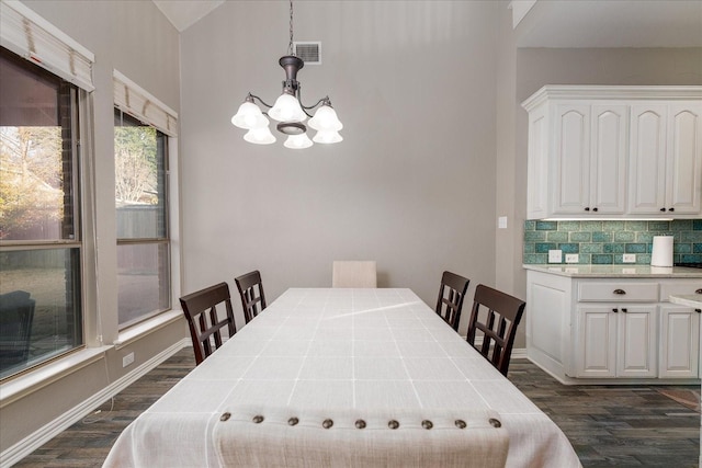 dining space with a chandelier, dark wood-style flooring, visible vents, baseboards, and vaulted ceiling