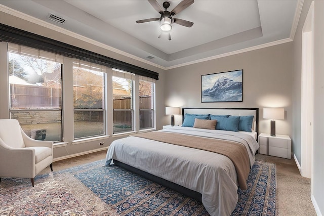 carpeted bedroom with baseboards, visible vents, a raised ceiling, and ornamental molding