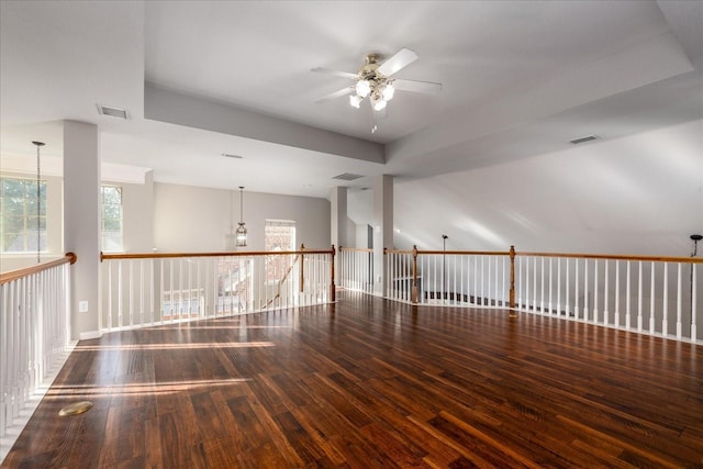 unfurnished room featuring ceiling fan with notable chandelier, hardwood / wood-style flooring, and visible vents