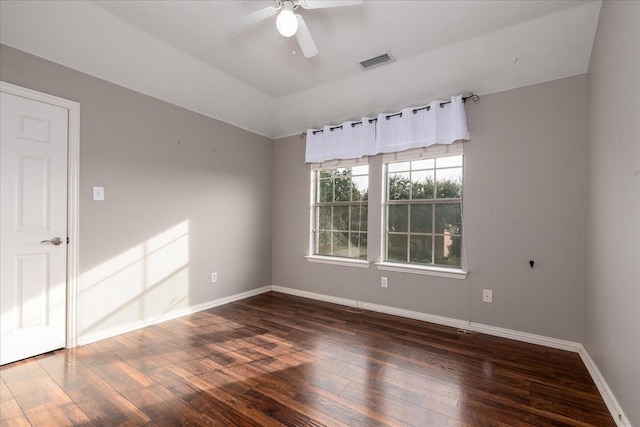 unfurnished room with a ceiling fan, wood-type flooring, visible vents, and baseboards