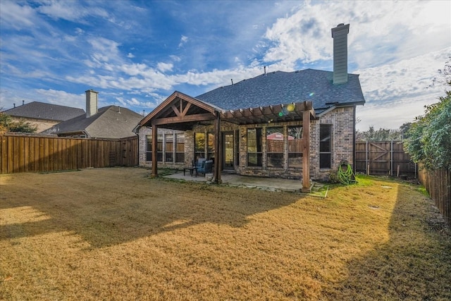 rear view of house featuring brick siding, a patio, a chimney, a lawn, and a fenced backyard