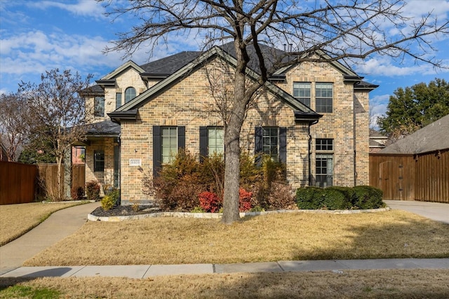 view of front of house with a gate, fence, and brick siding