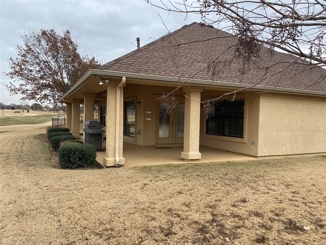 back of property with a yard and a patio area