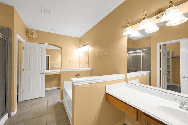 bathroom with tile patterned flooring, plus walk in shower, and vanity