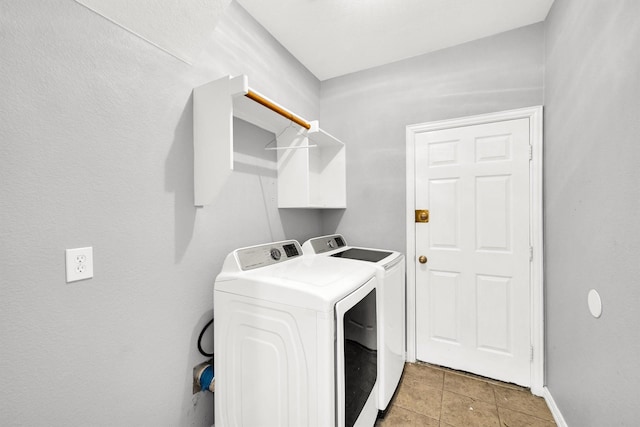 washroom with light tile patterned floors and washing machine and clothes dryer