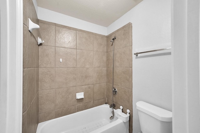 bathroom with tiled shower / bath combo and toilet