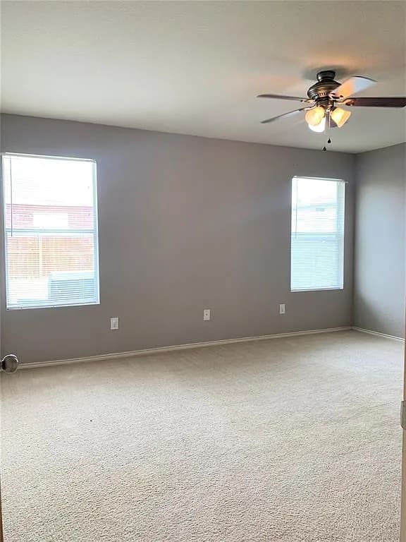 unfurnished room with ceiling fan and light colored carpet