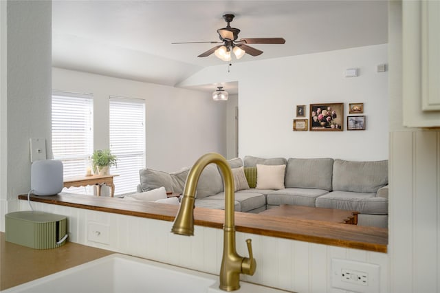 living room featuring lofted ceiling, sink, and ceiling fan