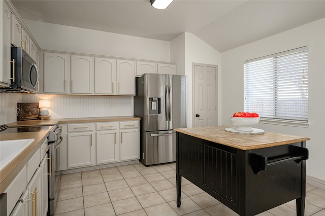 kitchen featuring white cabinetry, light tile patterned floors, backsplash, and stainless steel appliances