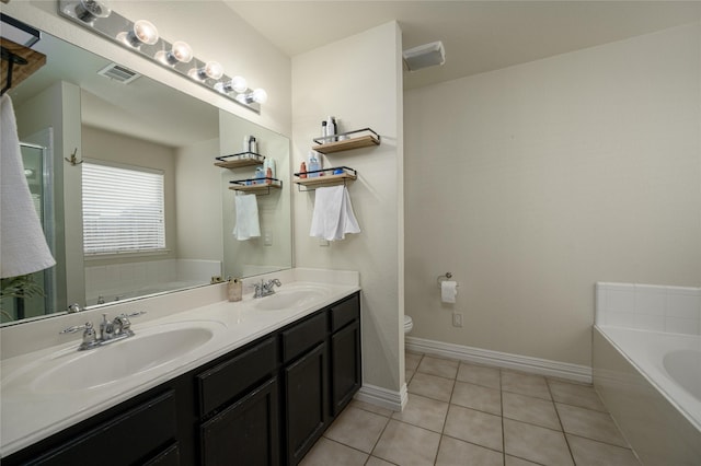 bathroom with tile patterned floors, toilet, vanity, and a washtub