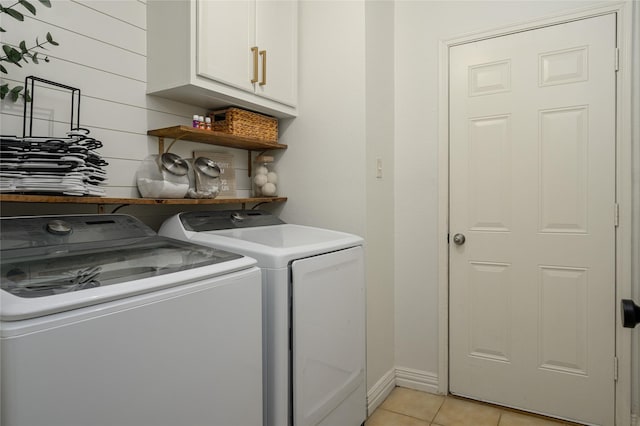 laundry area featuring cabinets, washer and dryer, and light tile patterned floors