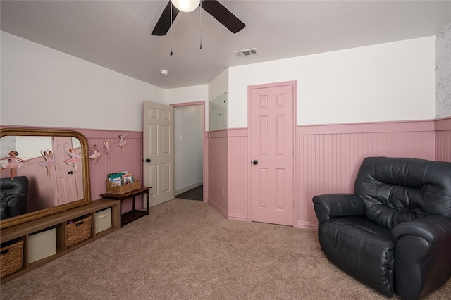 living area with light carpet and ceiling fan