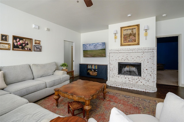 living room with ceiling fan, wood-type flooring, and a fireplace