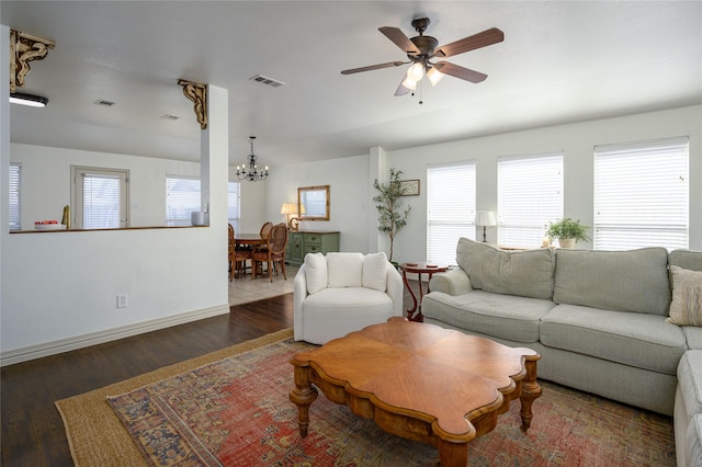 living room featuring dark hardwood / wood-style flooring and ceiling fan with notable chandelier