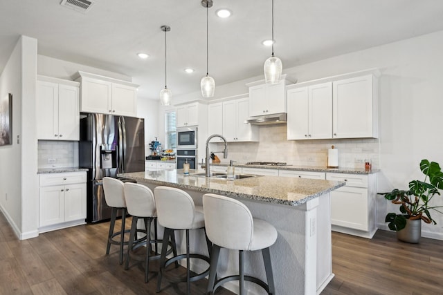 kitchen featuring appliances with stainless steel finishes, sink, a center island with sink, and white cabinets