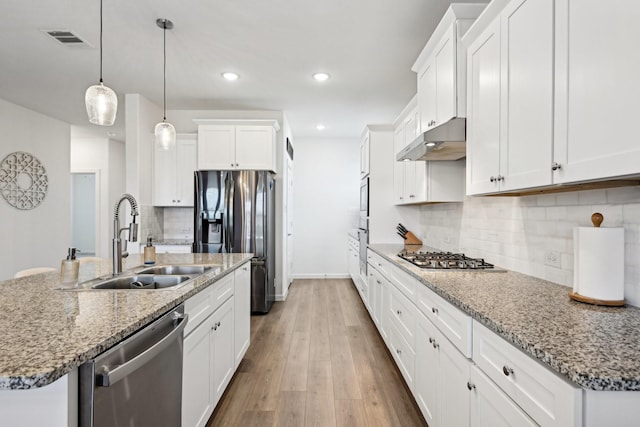 kitchen with stainless steel appliances, sink, hanging light fixtures, and white cabinets