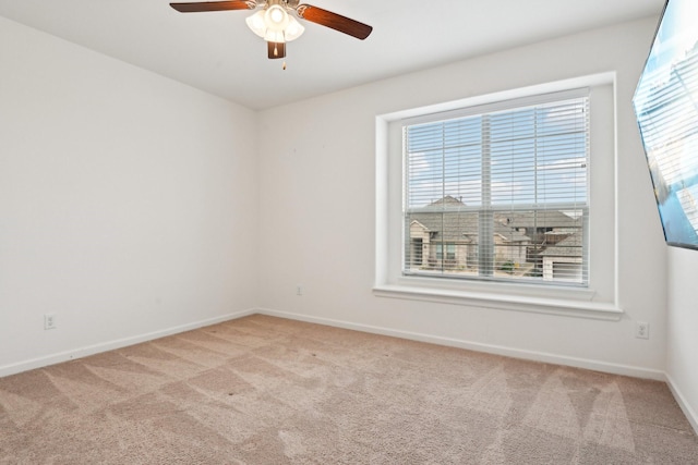 empty room featuring light carpet, ceiling fan, and a healthy amount of sunlight