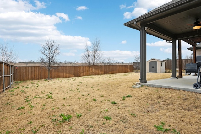 view of yard with ceiling fan, a shed, and a patio area