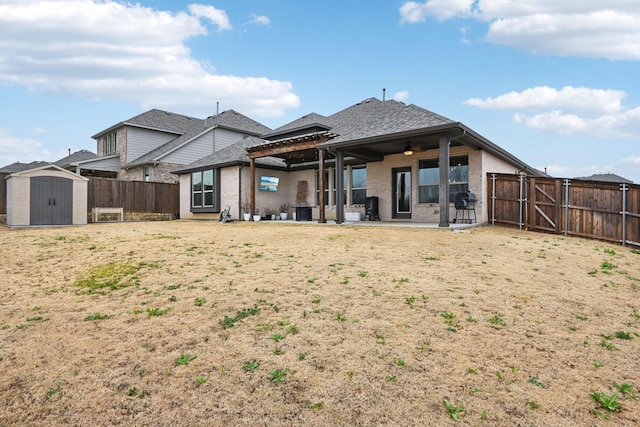 rear view of property featuring a patio, ceiling fan, and a storage unit