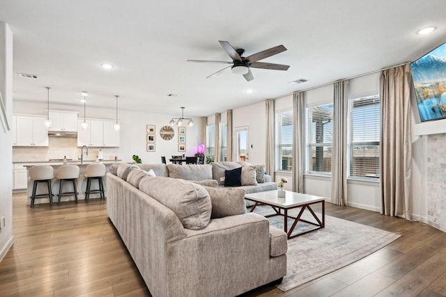 living room featuring sink, hardwood / wood-style floors, and ceiling fan