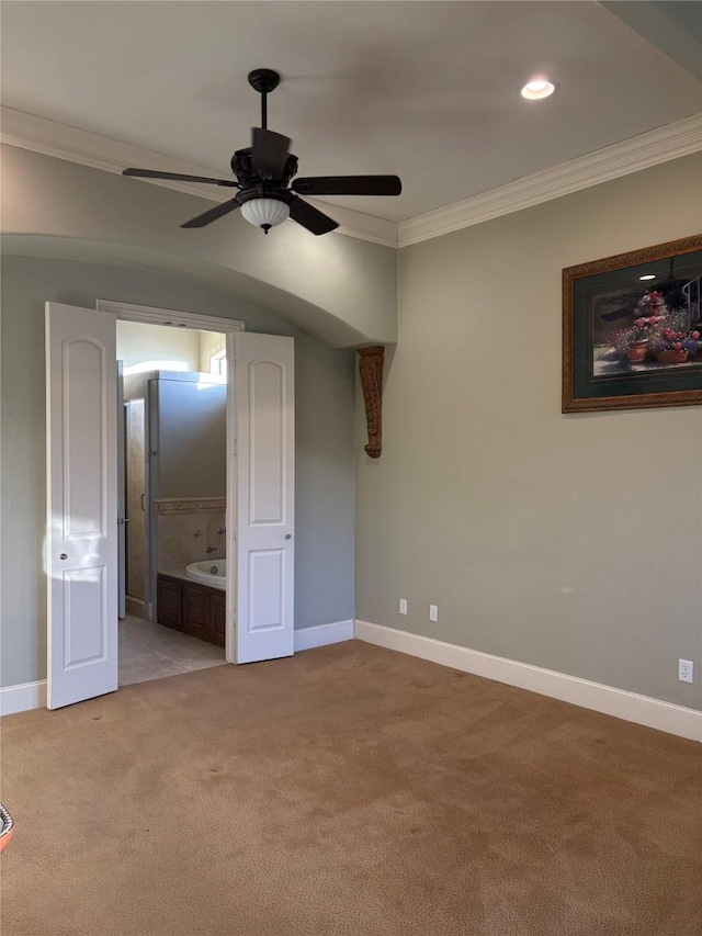 unfurnished bedroom with light carpet, ensuite bathroom, baseboards, and ornamental molding