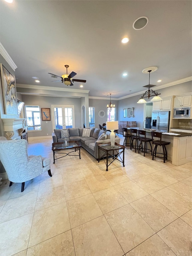 living room with light tile patterned floors, recessed lighting, ceiling fan with notable chandelier, and ornamental molding