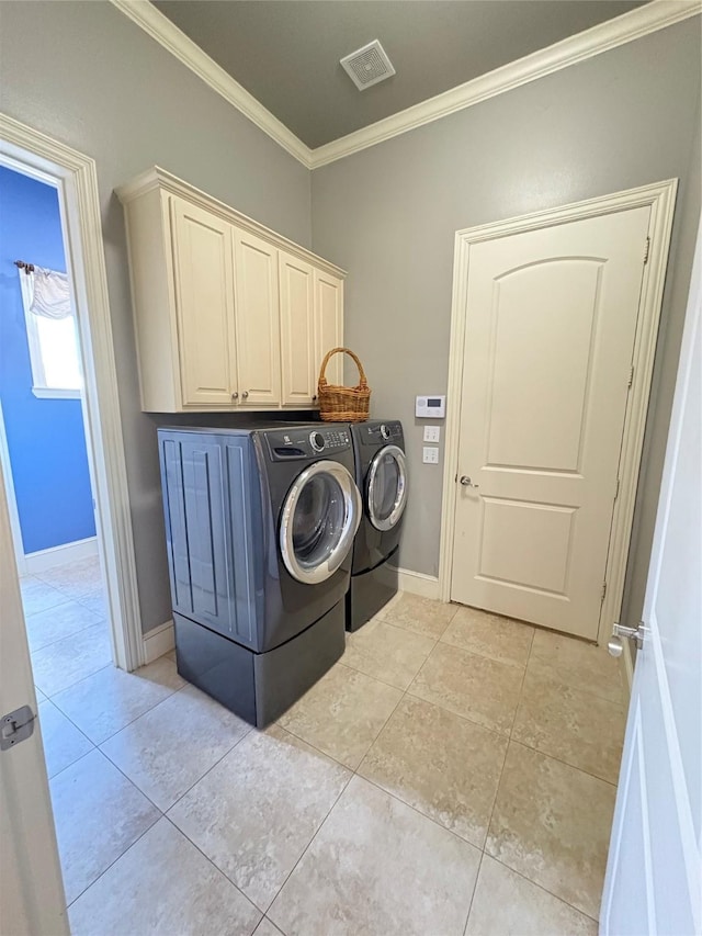 clothes washing area featuring visible vents, ornamental molding, light tile patterned floors, washer and dryer, and cabinet space