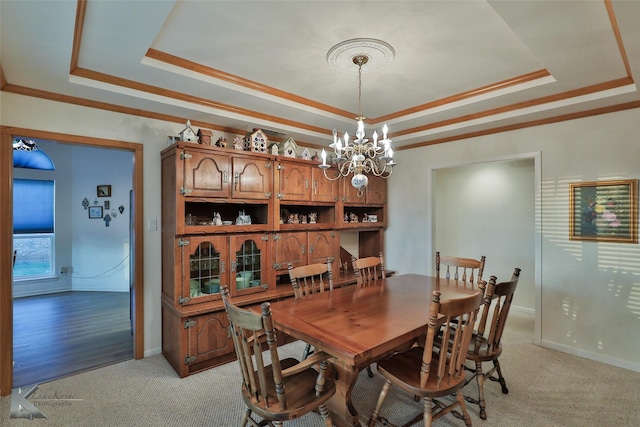 carpeted dining area featuring an inviting chandelier, ornamental molding, and a raised ceiling