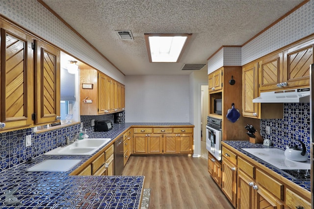 kitchen with appliances with stainless steel finishes, tasteful backsplash, sink, crown molding, and a textured ceiling