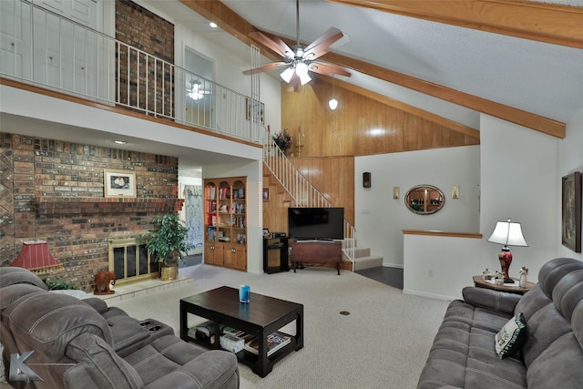 living room featuring beam ceiling, wood walls, high vaulted ceiling, a fireplace, and carpet