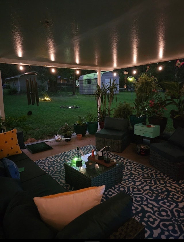 patio at night featuring a yard, an outdoor hangout area, and a shed