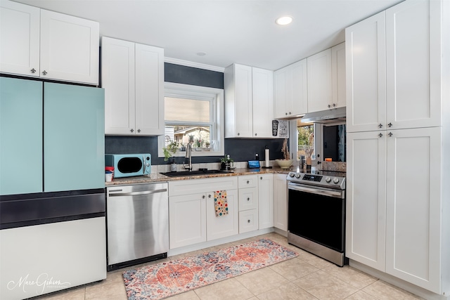 kitchen featuring sink, stainless steel appliances, white cabinets, and light stone countertops