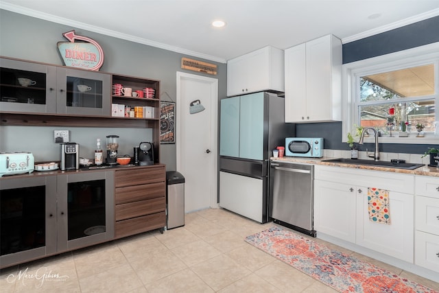 kitchen with sink, crown molding, refrigerator, white cabinets, and stainless steel dishwasher