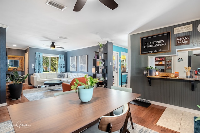 dining room with crown molding, ceiling fan, and light hardwood / wood-style floors