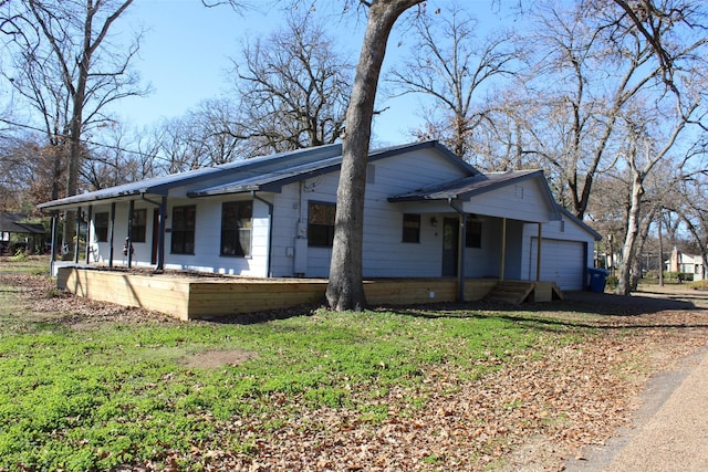 view of front of home with a porch, a garage, and a front lawn