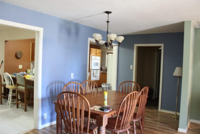 dining area with hardwood / wood-style flooring and a chandelier