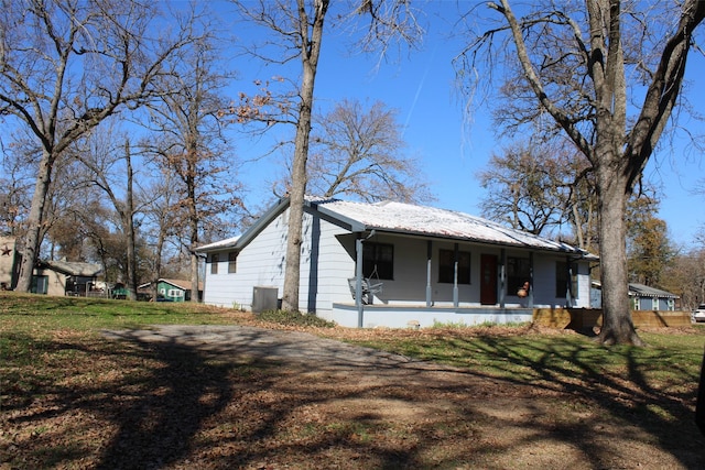 view of front facade with a porch, cooling unit, and a front lawn