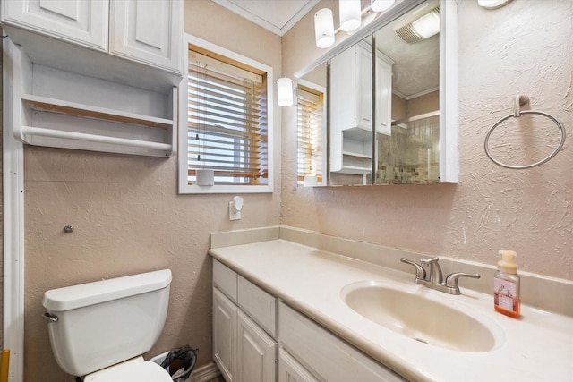 bathroom with ornamental molding, a shower with shower door, vanity, and toilet