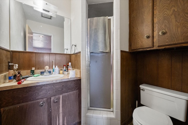 bathroom with wooden walls, vanity, toilet, and an enclosed shower