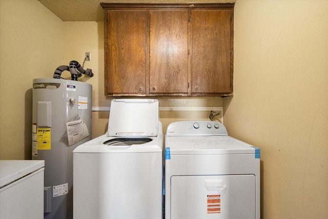 laundry area featuring independent washer and dryer, cabinets, water heater, and a textured ceiling